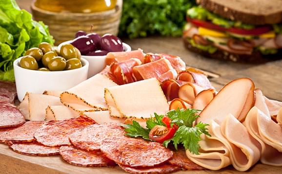 wooden board with cheese and cold cuts